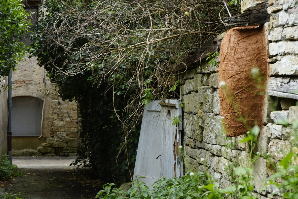 Semiostalgia P0013 — Sculpture fraîche, en terre crue, sable, filasse végétale, paille, grillage à poule, sur mur de pierre calcaire, Saint-Antonin-Noble-Val